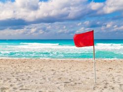 red warning flag on a stormy beach