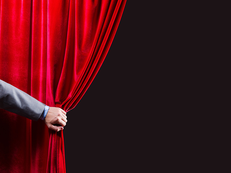 man opening curtain to reveal something