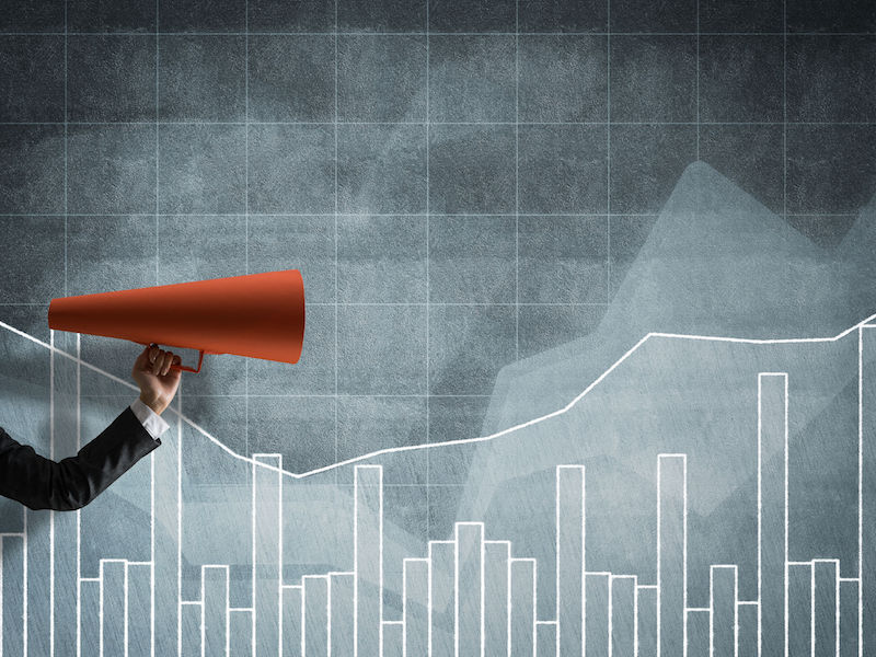 Close of businesswoman making announcement in paper trumpet