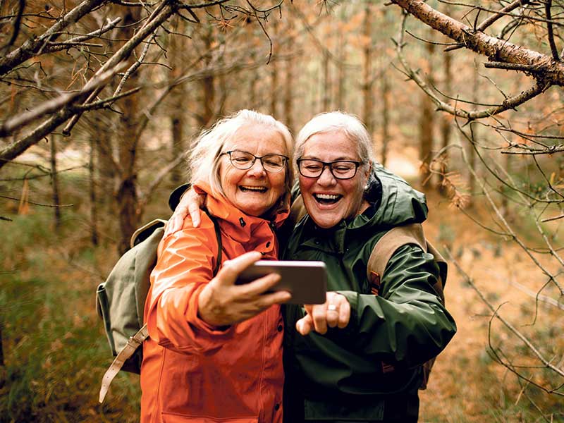 Two senior ladies hiking in the woods