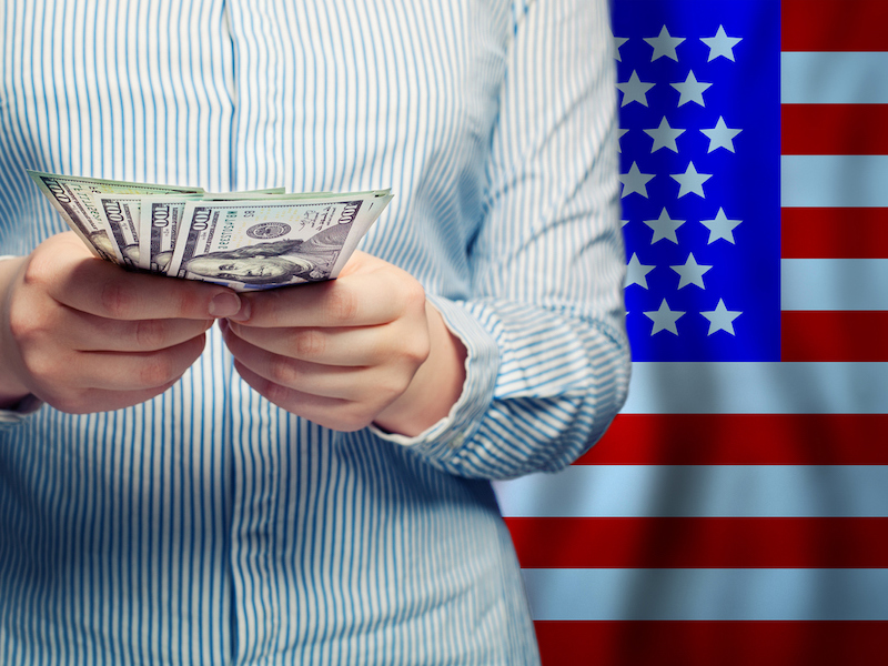 Hands counts money on American flag background