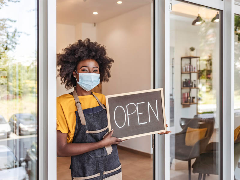 business owner with open sign