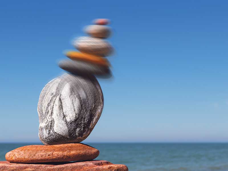 Rock sculpture on the beach with unstable top