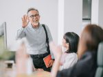 senior colleague back to work with face mask greeting on each other in office morning stock photo