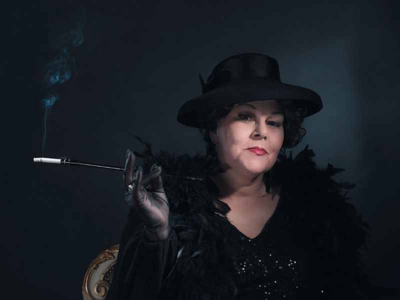 Retro woman wearing hat and smoking cigarette. 1930s classic portrait.